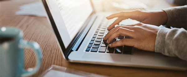 closeup of hands typing on a laptop